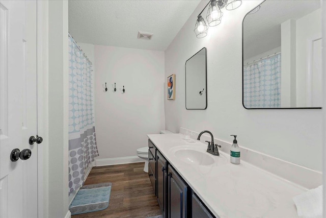 28 S Comares Ave, Saint Augustine, FL 32080 - full bathroom with vanity, wood finished floors, toilet, baseboards, and a textured ceiling