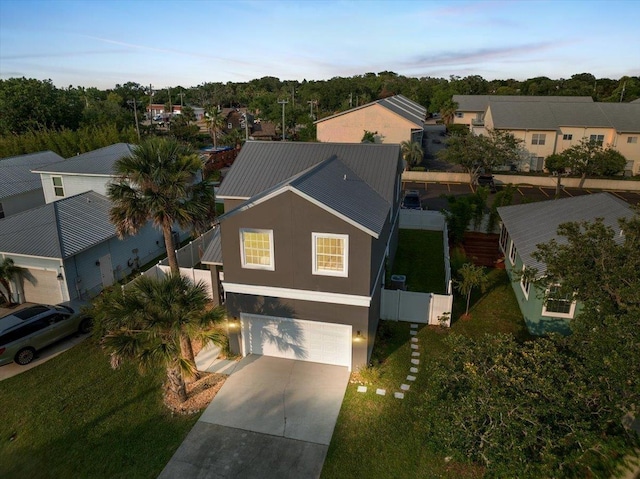 28 S Comares Ave, Saint Augustine, FL 32080 - view of front of house featuring an attached garage, concrete driveway, metal roof, a residential view, and stucco siding