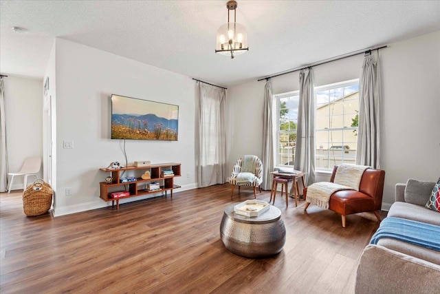 28 S Comares Ave, Saint Augustine, FL 32080 - living area featuring wood finished floors, a chandelier, baseboards, and a textured ceiling