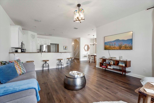 28 S Comares Ave, Saint Augustine, FL 32080 - living room with a chandelier, dark wood finished floors, baseboards, and a textured ceiling