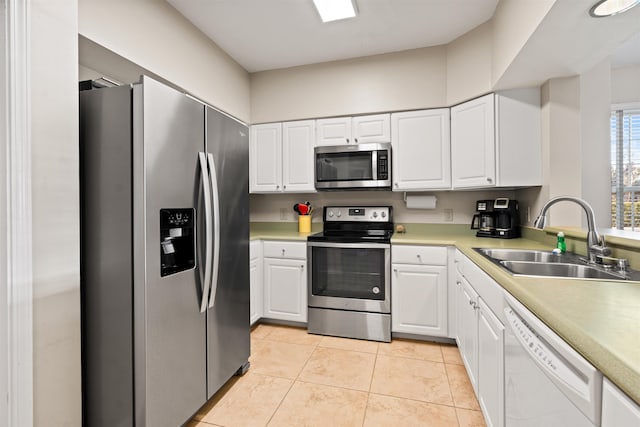 kitchen featuring sink, white cabinetry, stainless steel appliances, and light tile patterned floors