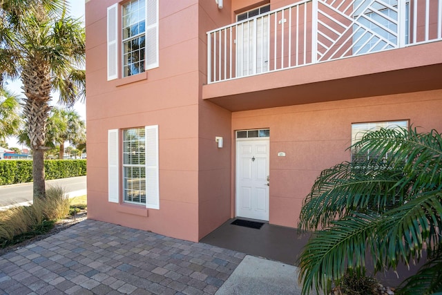 view of exterior entry with a balcony