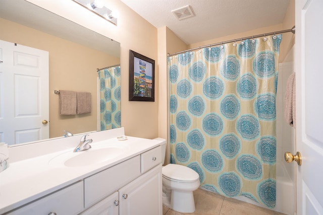 bathroom with tile patterned flooring, vanity, toilet, and a textured ceiling