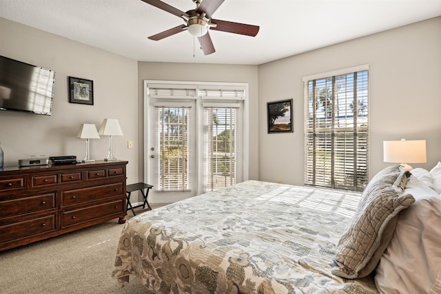 bedroom featuring access to outside, light colored carpet, multiple windows, and ceiling fan