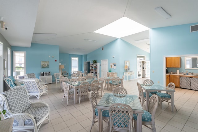 dining space with light tile patterned flooring and lofted ceiling