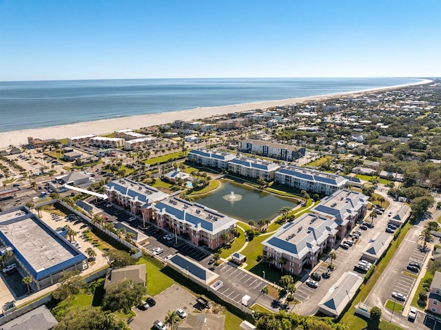 birds eye view of property with a water view and a view of the beach