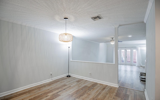 empty room featuring a textured ceiling, light hardwood / wood-style floors, ceiling fan, and ornamental molding