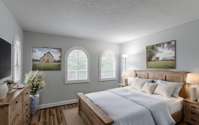 bedroom featuring a textured ceiling and dark hardwood / wood-style floors