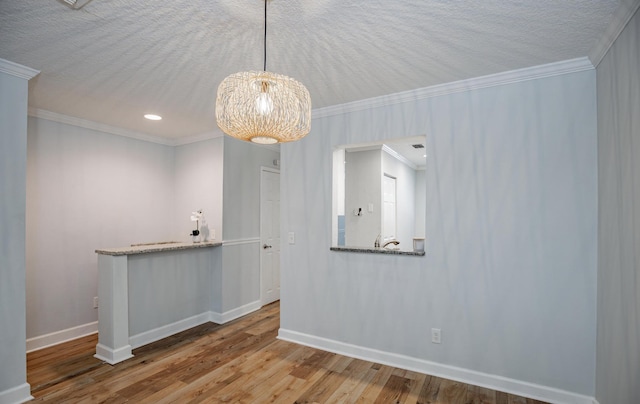 unfurnished dining area with crown molding, hardwood / wood-style floors, and a textured ceiling