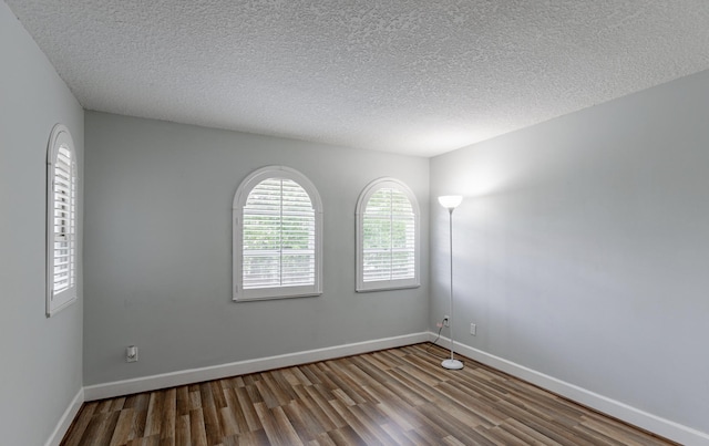 spare room featuring a textured ceiling and hardwood / wood-style flooring