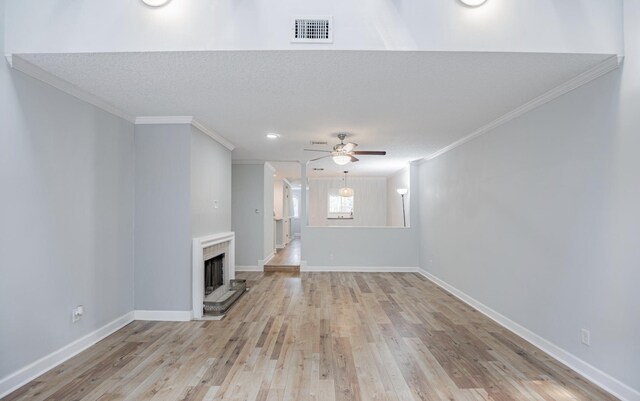 unfurnished living room with ceiling fan, crown molding, light hardwood / wood-style floors, and a textured ceiling