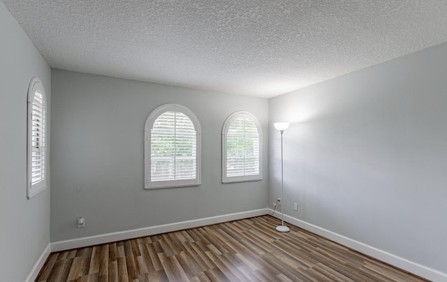 spare room featuring a textured ceiling and hardwood / wood-style flooring