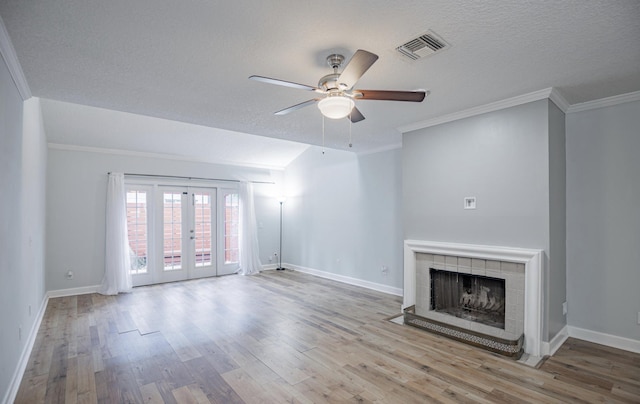 unfurnished living room with ceiling fan, french doors, a fireplace, and light hardwood / wood-style flooring