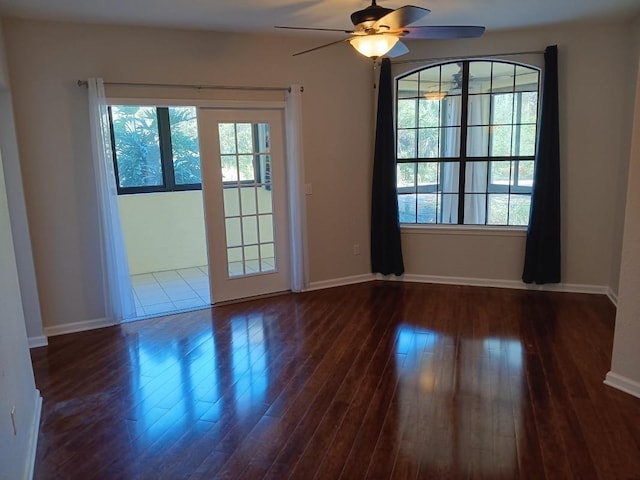 spare room with baseboards, wood finished floors, and a ceiling fan