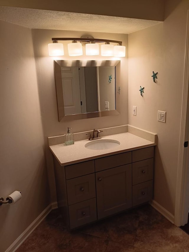 bathroom featuring vanity, baseboards, and a textured ceiling