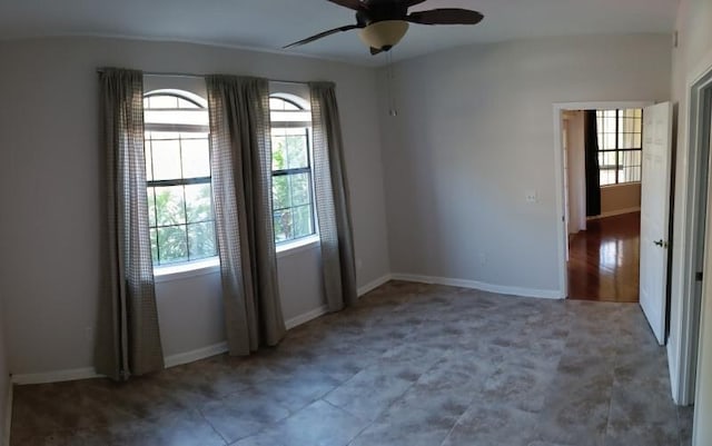 spare room with baseboards and ceiling fan