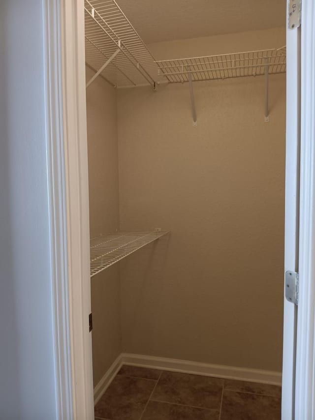 spacious closet featuring dark tile patterned floors