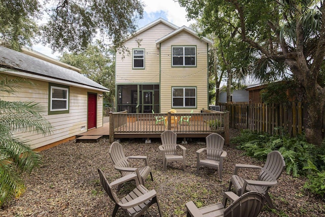 back of house featuring a sunroom and a wooden deck