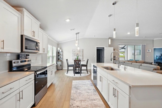 52 Lumberjack Trl, Palm Coast, FL 32137 - kitchen featuring stainless steel appliances, light wood-type flooring, decorative backsplash, white cabinetry, and light countertops