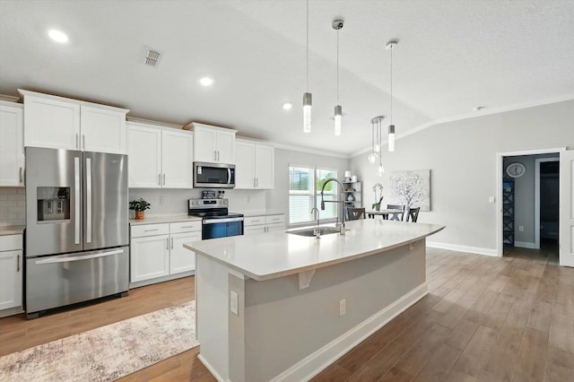 52 Lumberjack Trl, Palm Coast, FL 32137 - kitchen featuring appliances with stainless steel finishes, lofted ceiling, ornamental molding, light countertops, and light wood-type flooring