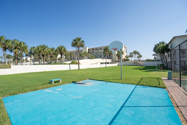 view of sport court featuring a lawn