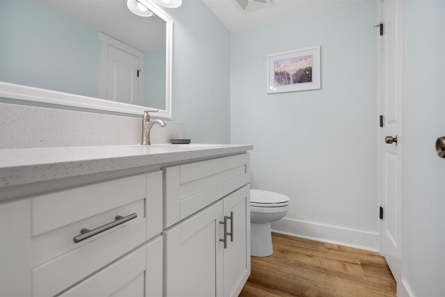 bathroom featuring hardwood / wood-style floors, vanity, and toilet