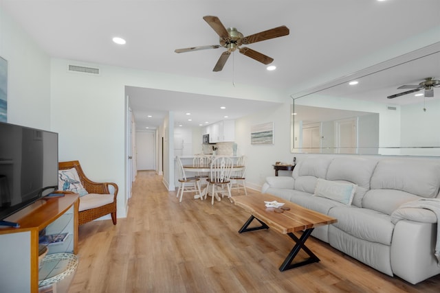 living room with ceiling fan and light hardwood / wood-style flooring