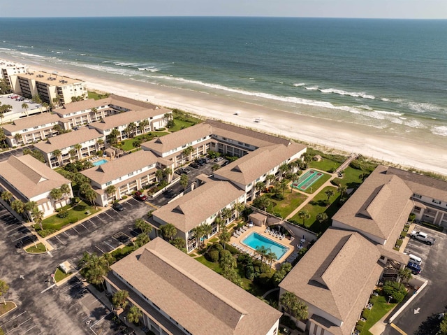 birds eye view of property featuring a beach view and a water view