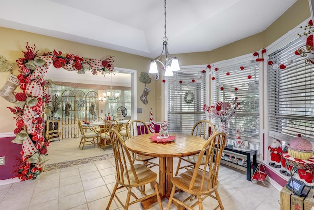 dining space with light tile patterned floors and an inviting chandelier