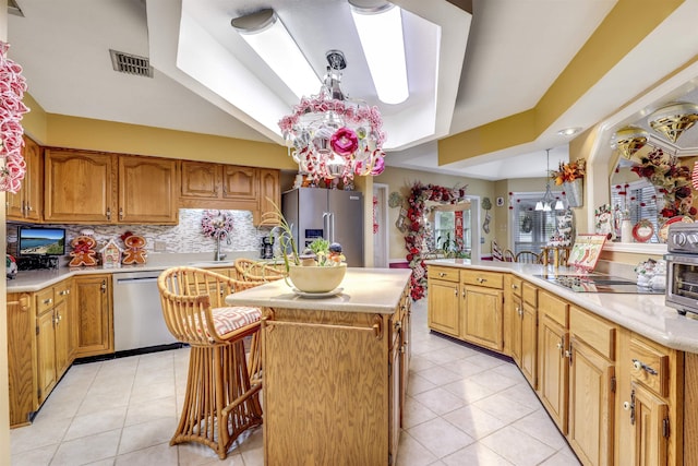 kitchen featuring tasteful backsplash, a breakfast bar, stainless steel appliances, light tile patterned floors, and an island with sink