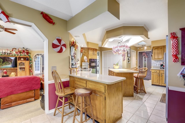 kitchen featuring a center island, double oven, kitchen peninsula, a breakfast bar area, and decorative backsplash