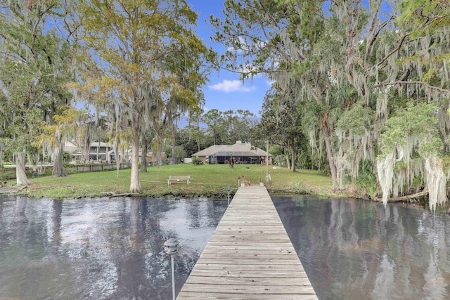 dock area with a yard and a water view