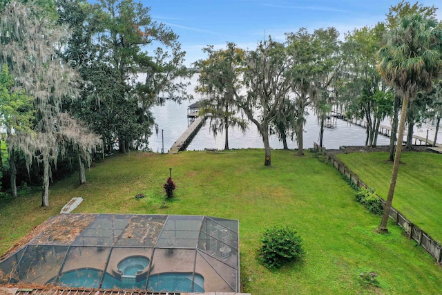 view of yard with a swimming pool with hot tub, a lanai, a dock, and a water view