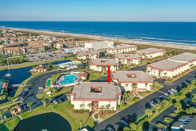 birds eye view of property featuring a water view and a beach view