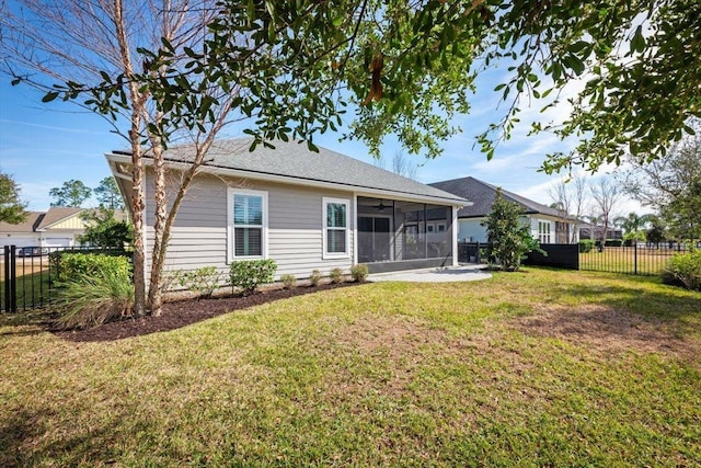 rear view of house featuring a sunroom and a yard