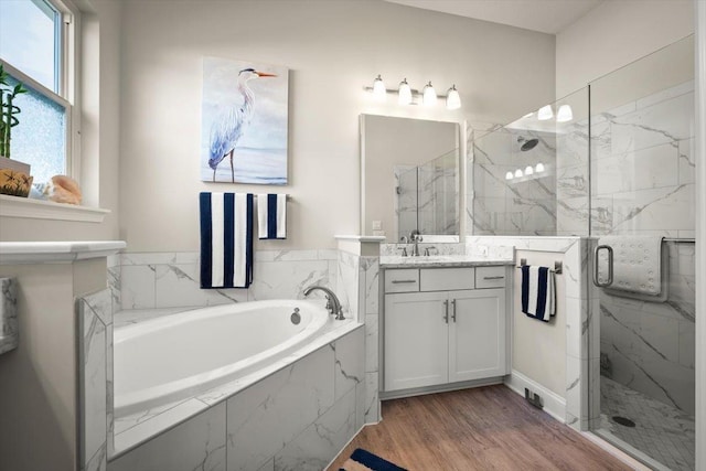 bathroom with plus walk in shower, hardwood / wood-style floors, and vanity