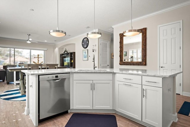 kitchen with sink, white cabinetry, light stone counters, decorative light fixtures, and dishwasher