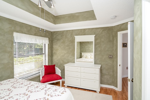 bedroom with a textured ceiling, light hardwood / wood-style flooring, and ornamental molding