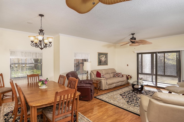 dining room featuring a textured ceiling, crown molding, ceiling fan with notable chandelier, and hardwood / wood-style flooring