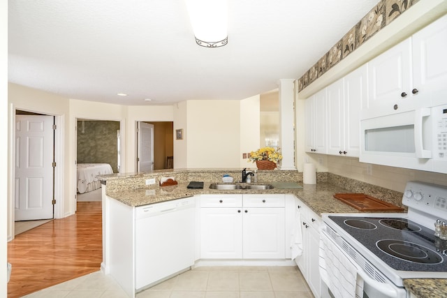 kitchen featuring kitchen peninsula, white cabinetry, sink, and white appliances