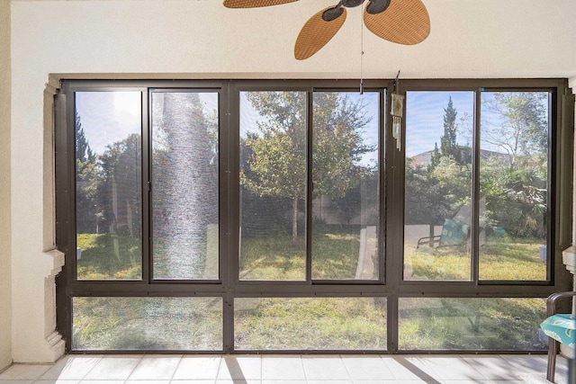 unfurnished sunroom with ceiling fan