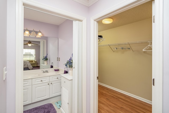 bathroom featuring vanity, hardwood / wood-style floors, a textured ceiling, and ceiling fan