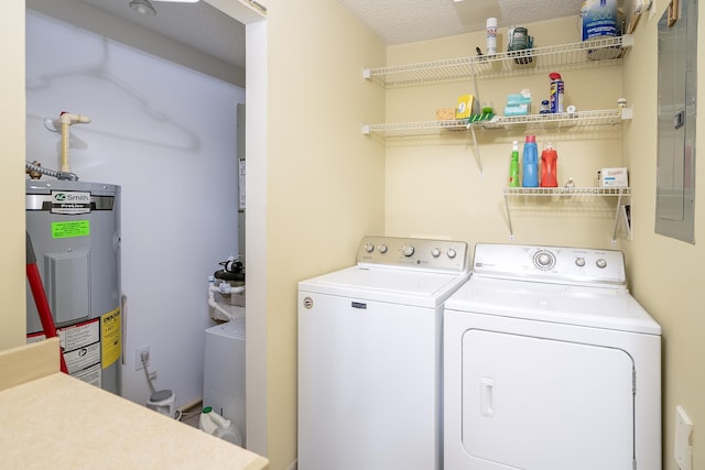 clothes washing area with washer and dryer, a textured ceiling, electric water heater, and electric panel