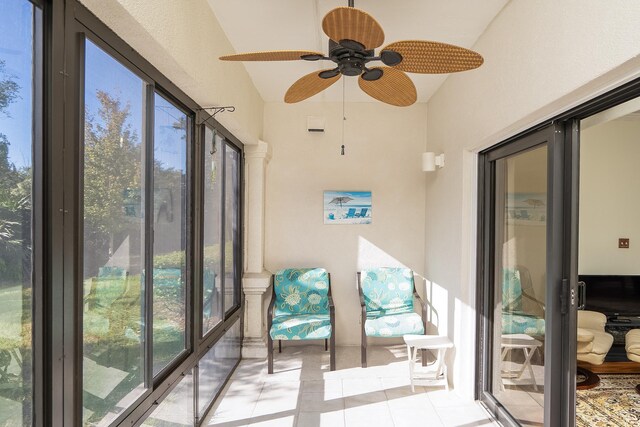 sunroom / solarium with plenty of natural light, lofted ceiling, and ceiling fan