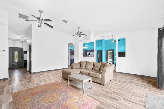 4405 Alvin St, Hastings, FL 32145 - living room with ceiling fan, arched walkways, light wood-type flooring, a towering ceiling, and baseboards
