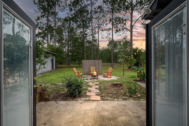 4405 Alvin St, Hastings, FL 32145 - yard at dusk featuring a fire pit, a patio area, and a lawn