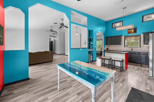 4405 Alvin St, Hastings, FL 32145 - game room with light wood-style flooring, a ceiling fan, a sink, vaulted ceiling, and arched walkways