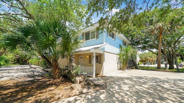 108 A St Unit A, Saint Augustine, FL 32080 - view of front of property featuring covered porch, stucco siding, and concrete driveway