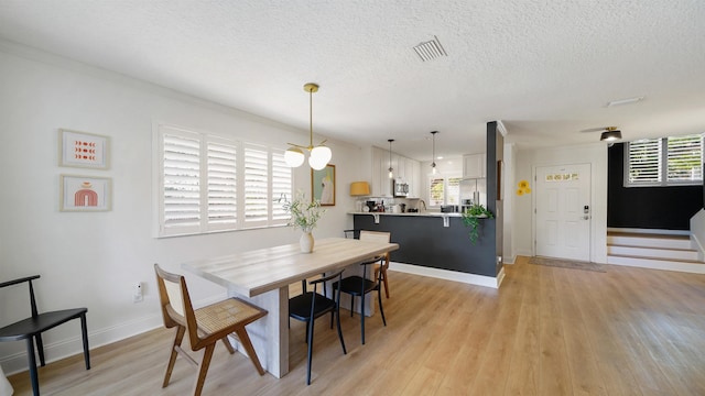 108 A St Unit A, Saint Augustine, FL 32080 - dining room with a textured ceiling and light wood-style floors