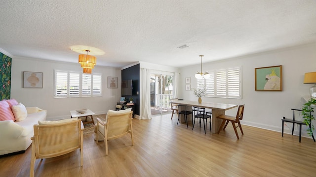 108 A St Unit A, Saint Augustine, FL 32080 - dining area with healthy amount of natural light, a textured ceiling, light wood-style flooring, ornamental molding, and a chandelier